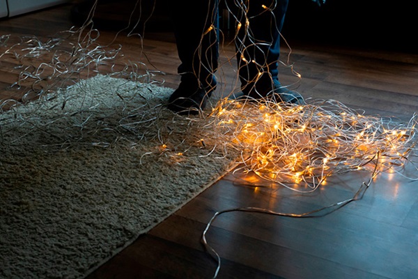 Un homme est en train de démêler une guirlande lumineuse de Noël